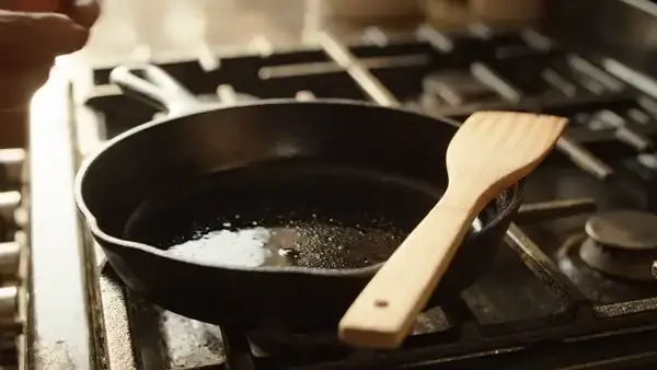 Brown eggs cracked one after the other into a black cast-iron skillet